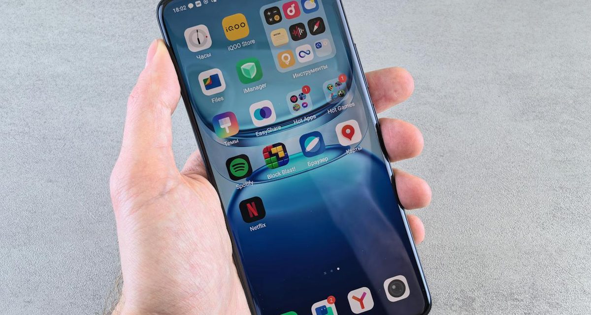 Hand holding a phone with app icons