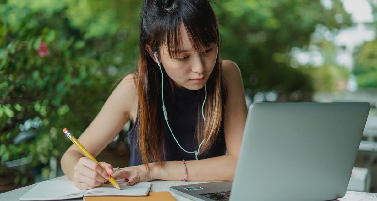 Studying a language with a laptop and notebook
