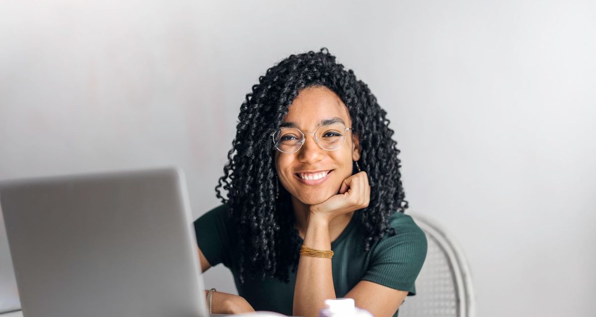 Smiling learner studying on a laptop